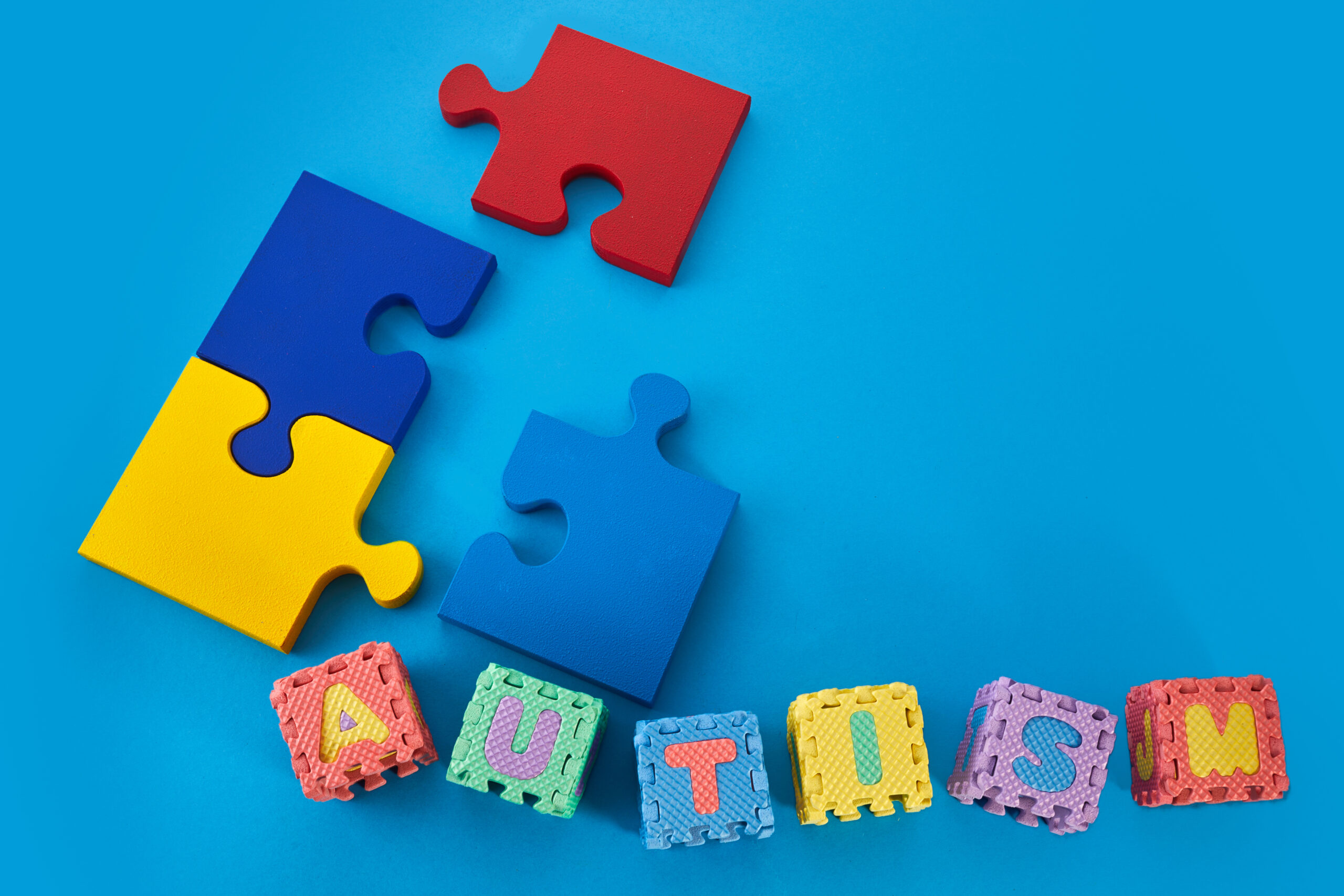 Word Autism on puzzle cubes on blue background. Autism awareness.